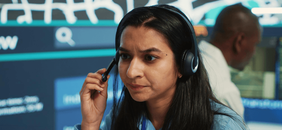 911 dispatcher at a computer-aided dispatch workstation taking an emergency call